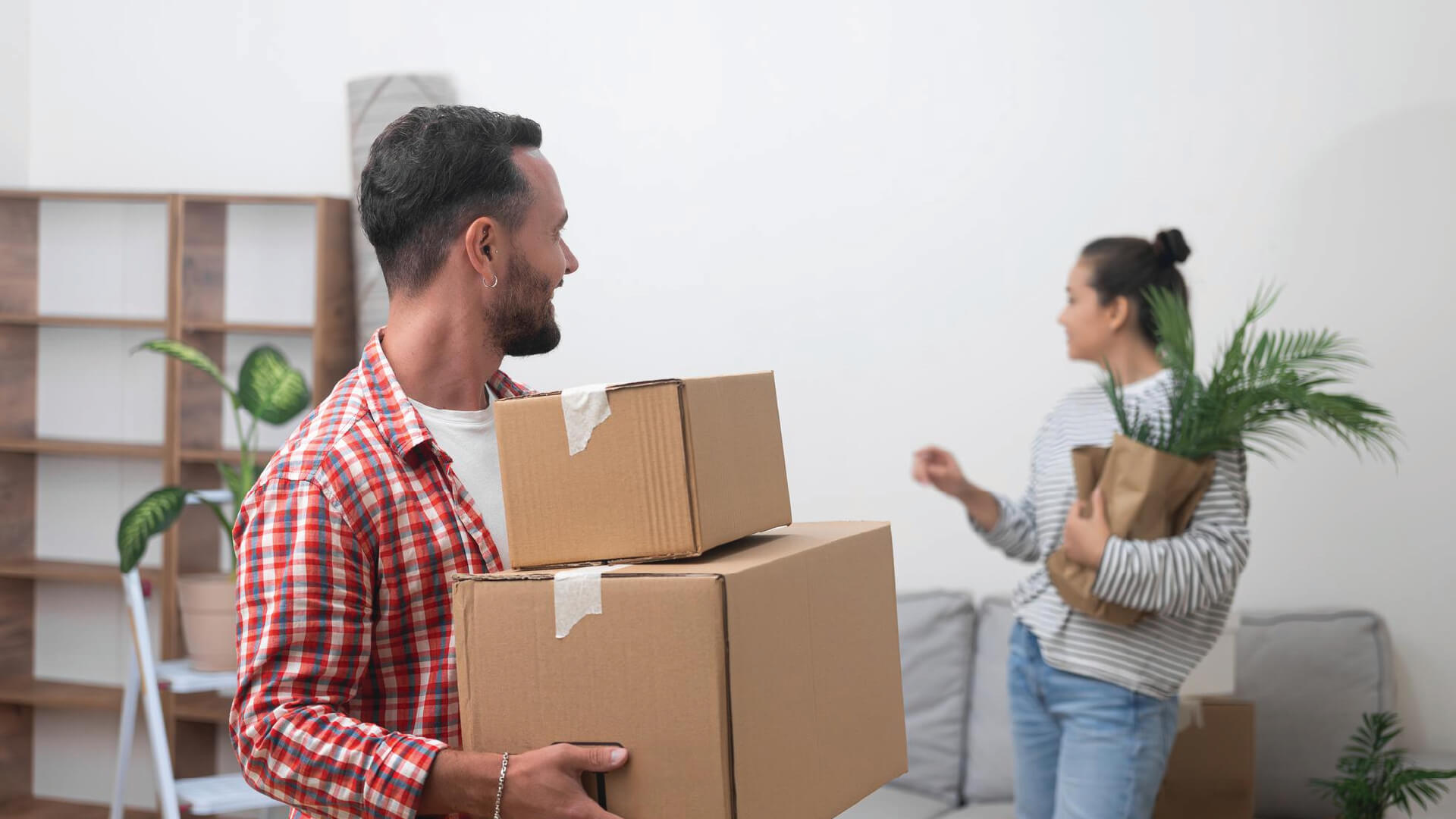 Human movers loading packed household boxes into a transport vehicle